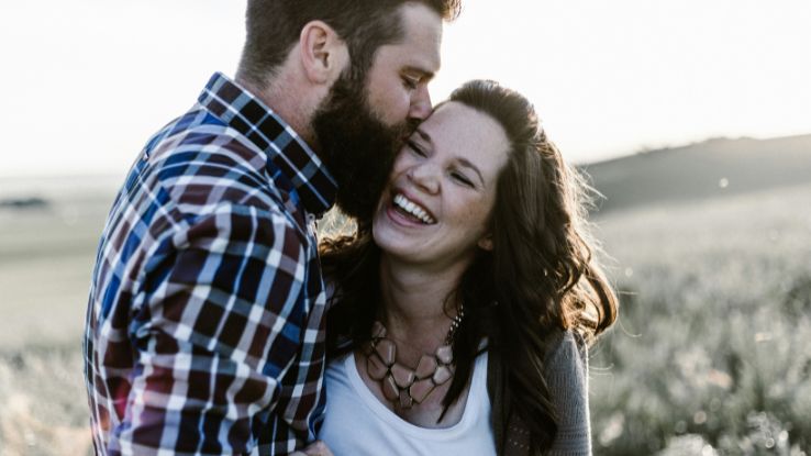 man kissing woman in grass area celebrating Valentine