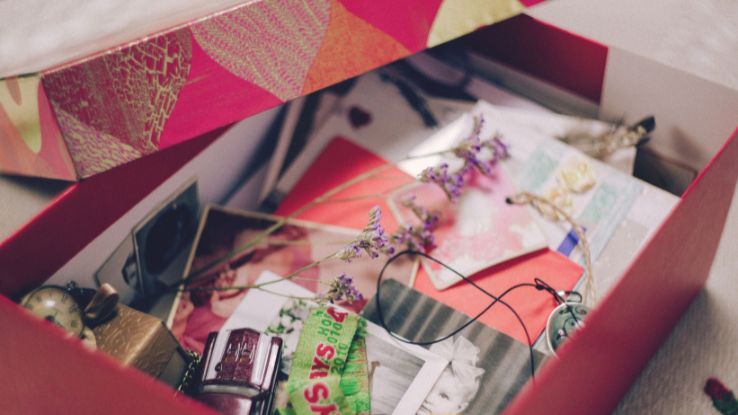 A colorful box filled with photographs, papers, and sentimental items, evoking nostalgia.
