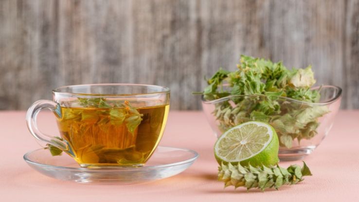 herbal-tea-with-herbs-lime-glass-cup-pink-wooden
